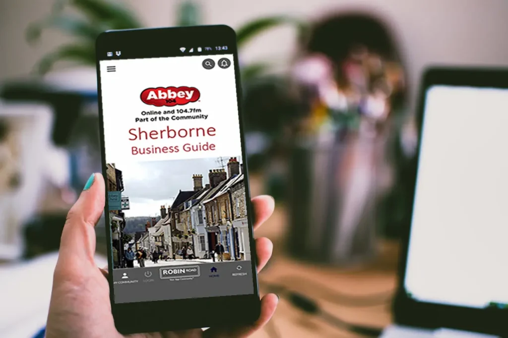 A person holding a smartphone looking at the Sherbourne Business Guide